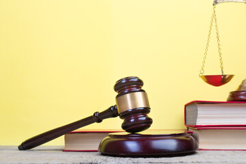 Law concept - Open law book, Judge's gavel, scales on table in a courtroom or law enforcement...