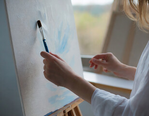 Woman artist painting on canvas with a brush