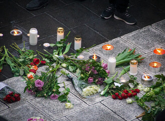 flowers and candles on the ground at the memorial service