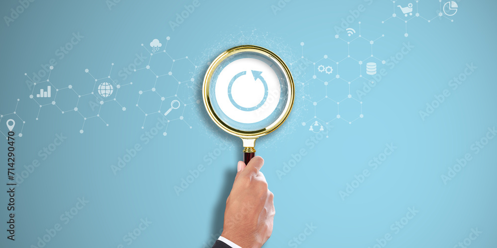 Poster backup. businessman hand holding a magnifying glass with backup icon on light blue background. data 