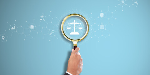 Law. Businessman Hand holding a magnifying glass with Legal Icon on Light Blue background. Legal Research, Compliance, Justice System. - obrazy, fototapety, plakaty