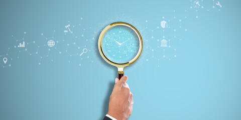 Time Management: Businessman Hand Holding a Magnifying Glass with Clock Icon on Light Blue...