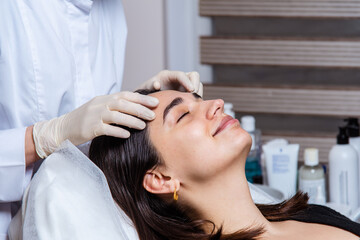 Naklejka premium Face and decollete relaxing and lifting massage with oil in the spa office