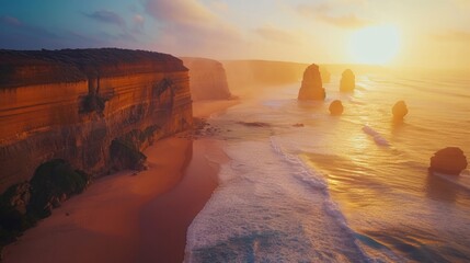 AERIAL: Spectacular drone point of view of the famous 12 Apostles beach in Australia on a sunny summer evening. Golden sunshine illuminates the cliffs and other rock formations on coast of Australia. - obrazy, fototapety, plakaty