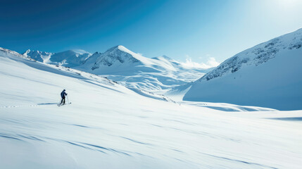 Solitary skier is trekking across a snowy mountain landscape under a bright sun.