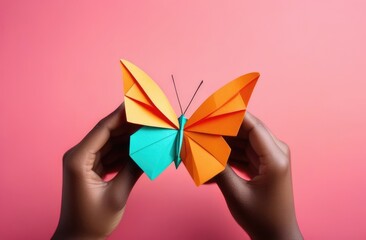 Zero Discrimination Day, colorful paper butterflies, origami butterfly in the hands of an African American woman, rainbow coloring, pink background