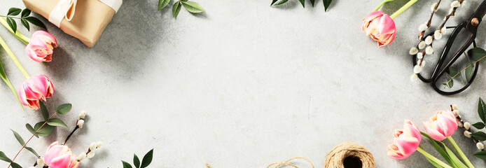 Banner. Easter background with spring flowers, eggs, feathers, gift boxes on light grey background - Powered by Adobe