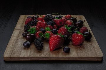 strawberries and blueberries on wooden table