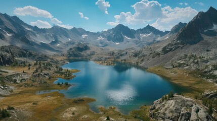  a blue lake surrounded by mountains under a blue sky with a few clouds in the middle of the lake is surrounded by grass, rocks, and a few trees, and a few clouds in the foreground.