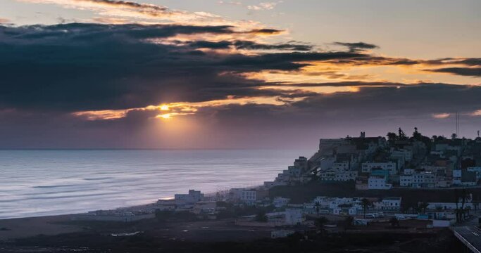 Golden sky sunset over ocean coast town in Morocco landscape Time lapse panorama