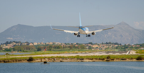 Fototapeta na wymiar the plane lands during the day to the runway of the airport Ioannis Kapodistrias of Greek island Corfu