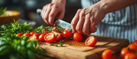 Fotobehang Female hands cutting cherry tomato for salad on wooden board © 2rogan