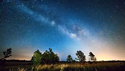 blue dark night sky with many stars above field of trees milkyw