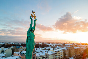 Beautiful sunset view over Riga by the statue of liberty - Milda in Latvia. The monument of freedom.