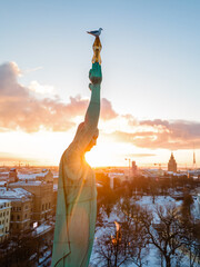 Beautiful sunset view over Riga by the statue of liberty - Milda in Latvia. The monument of freedom.