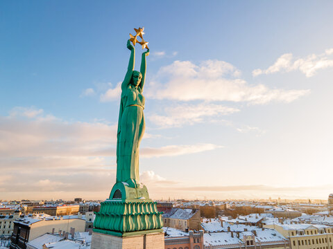Beautiful sunrise view over Riga by the statue of liberty - Milda in Latvia. The monument of freedom.