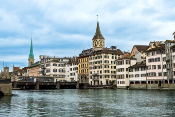 Fototapeta na wymiar Zurich city center, Switzerland. Zuerich old town with famous Fraumunster and St. Peter Church on bank of river Limmat in winter