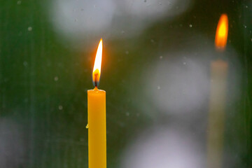 Lighted candle in a relaxing setting of faith and meditation