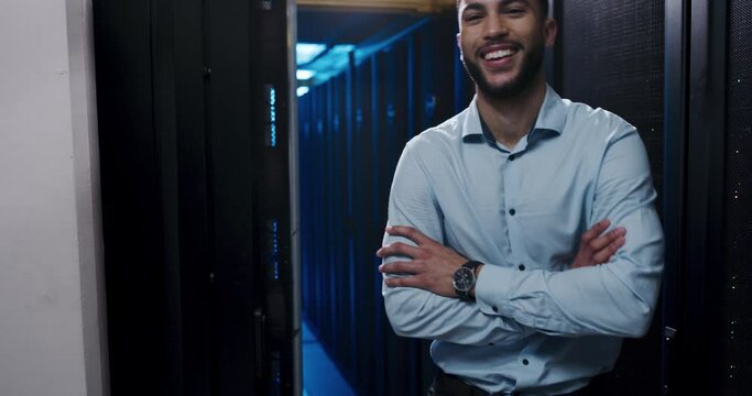 Technician, man and server room with arms crossed for information technology, business and cybersecurity. Face of happy engineer in data center backup, cloud computing solution or night maintenance