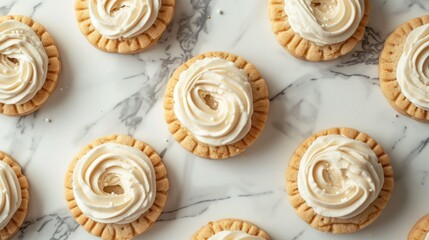  a marble table topped with lots of cookies covered in white frosting and a swirl of icing on top of one of the cookies on top of the cookies.