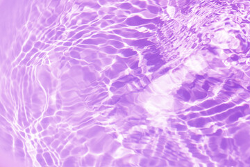 Purple water background. Pink water splashe on the surface ripple blur. Defocus blurred transparent...