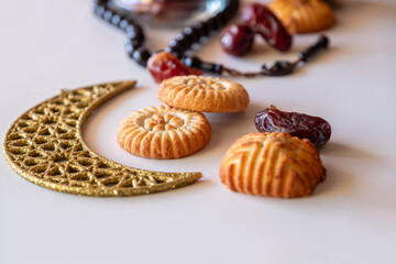 Variety of semolina maamoul cookies displayed with crescent ,star and Ramadan decorations. Traditional Arabic sweets for Eid al Adha and Eid al Fitr celebrations.