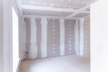 Interior of a house under renovation with drywall installation and joint compound application - obrazy, fototapety, plakaty