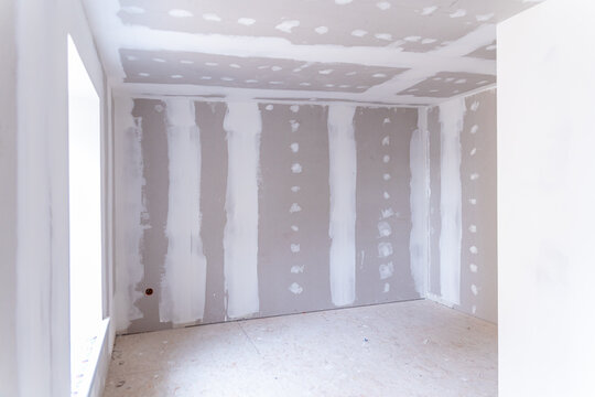 Interior of a house under renovation with drywall installation and joint compound application