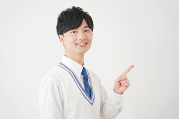 右側を指差す男子高校生　白背景