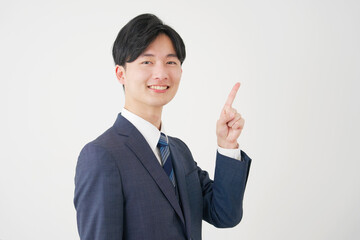 右側を指差す若いビジネスマン　白背景