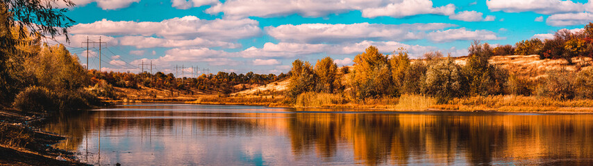 Azure Lake Surrounded by Orange Fields and Trees, Illuminated by Daytime Autumn Sunlight, Against a...