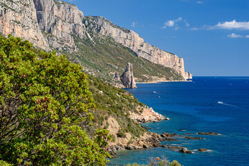 Fototapeta na wymiar Coastline near Santa Maria Navarrese with rock pinnacle called Pedra Longa in the background in east Sardinia