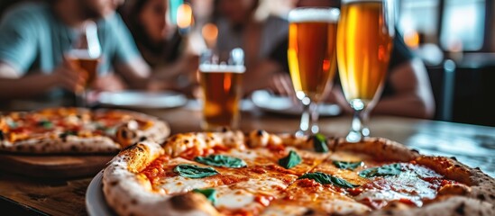 Group of friends enjoying a delicious pizza and beer at the restaurant.