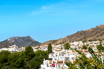 Fototapeta na wymiar White architecture in the city of Nerja, Spain. Panorama of the city and mountains.