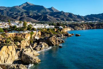 Little white house on the beach. View of the sea, city and mountains. Panorama of the city of Nerja, Spain.