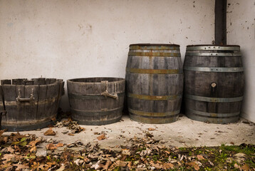 Old wooden barrels for wine and baskets in the courtyard of an old house. Vintage lifestyle...