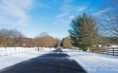 Fototapeta na wymiar Empty road in Colts Neck, New Jersey, after some snowfall, on a crisp, sunny, winter day -04