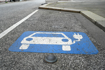 Electric vehicle charging sign on asphalt road. Parking reserved for electric cars. Charging...