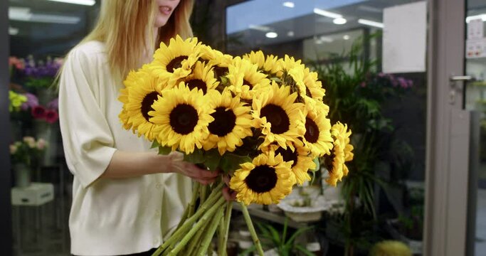  florist in a flower store shows sunflowers