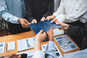 Corporate officer worker collaborate in office, connecting puzzle pieces with report paper on table...
