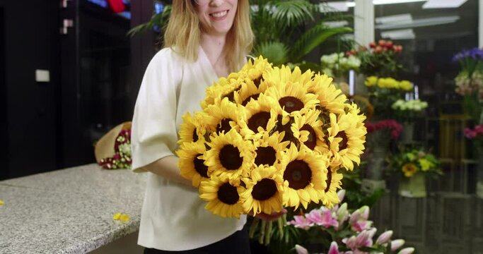  florist in a flower store shows sunflowers