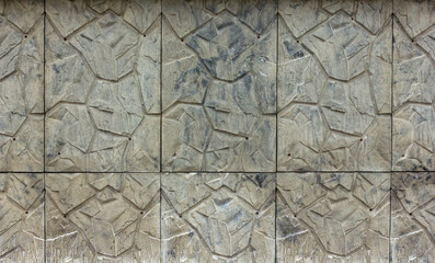 texture of a wall made of concrete slabs with an imitation pattern of natural stone with uneven edges close-up