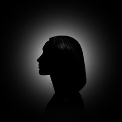 Silhouette of woman in darkness. Portrait on black background