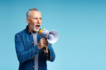Positive attractive senior man wearing casual stylish clothes holding loudspeaker looking away