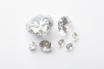 Many beautiful shiny diamonds on white background, flat lay