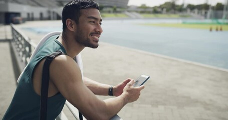Happy man, fitness and phone typing at stadium on break for communication or social media. Active male person or runner smile in relax or rest on mobile smartphone for online chatting, texting or app - Powered by Adobe