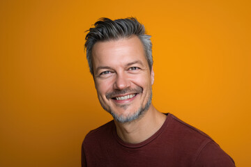 Fototapeta premium A man with gray hair and a beard smiles for the camera