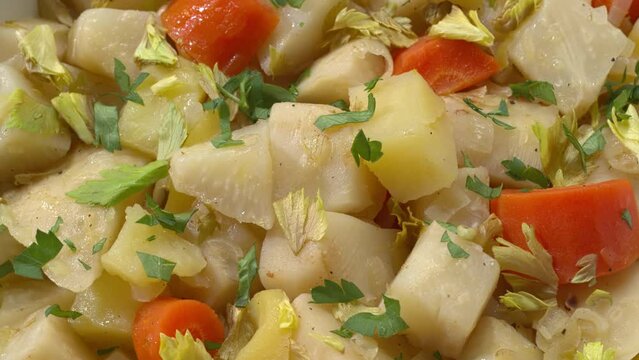 Macro view of Turkish-style braised celeriac (Zeytinyağlı kereviz). Abstract food texture. Table spin