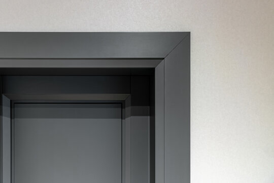 Fragment of a gray architrave and door in a new house