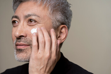 メンズビューティー/顔に手でクリームを塗る男性